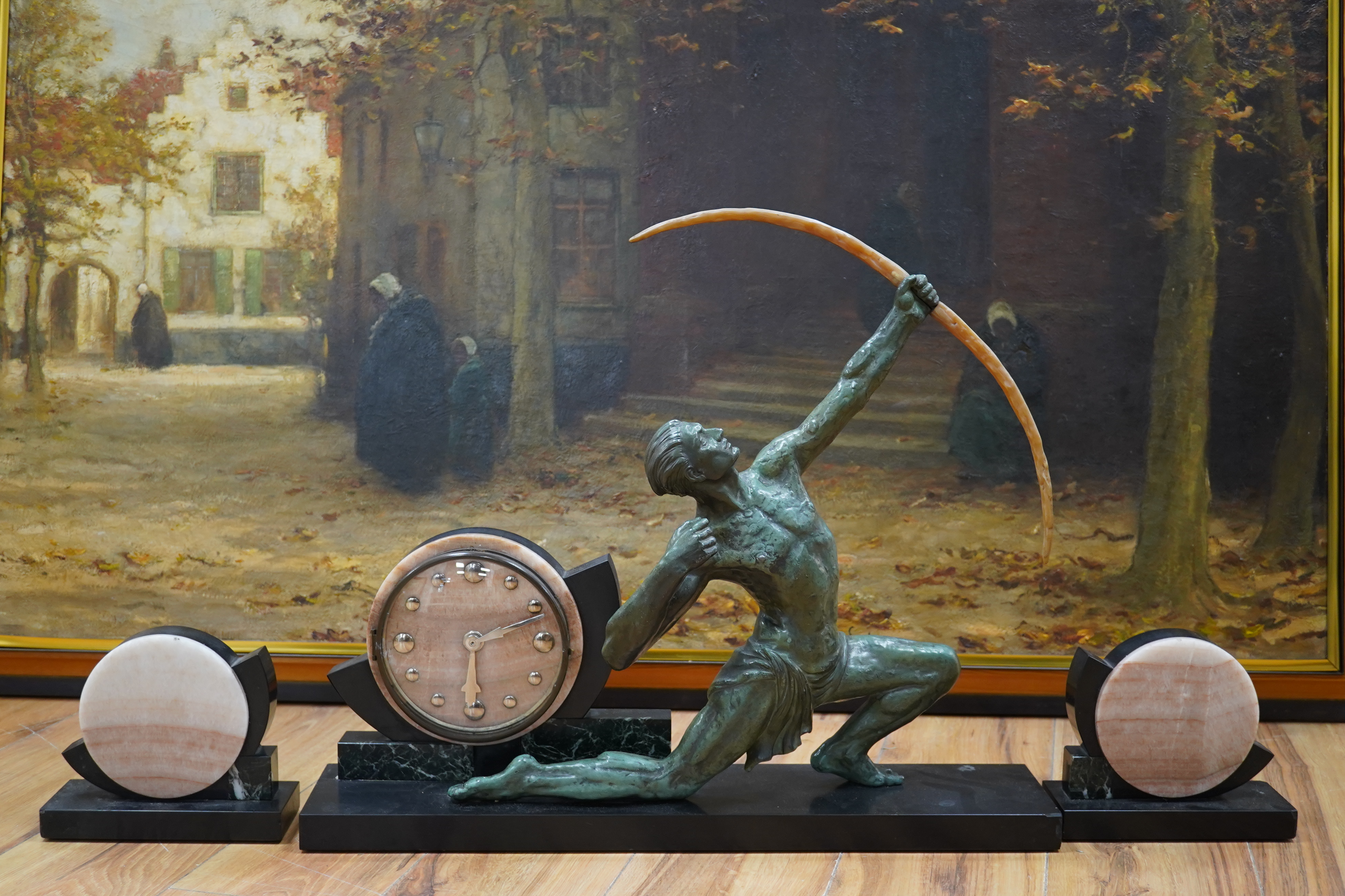 A French Art Deco spelter and marble ‘archer’ clock garniture, 60.5cm wide, 51.5cm high. Condition - fair to good